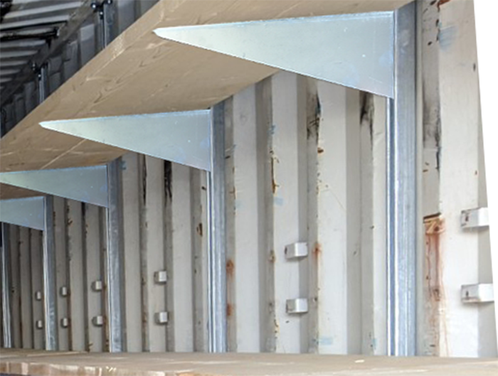Installed 18-inch galvanized bolt-on shelving brackets mounted on vertical strut channels inside a shipping container, supporting wooden shelves.