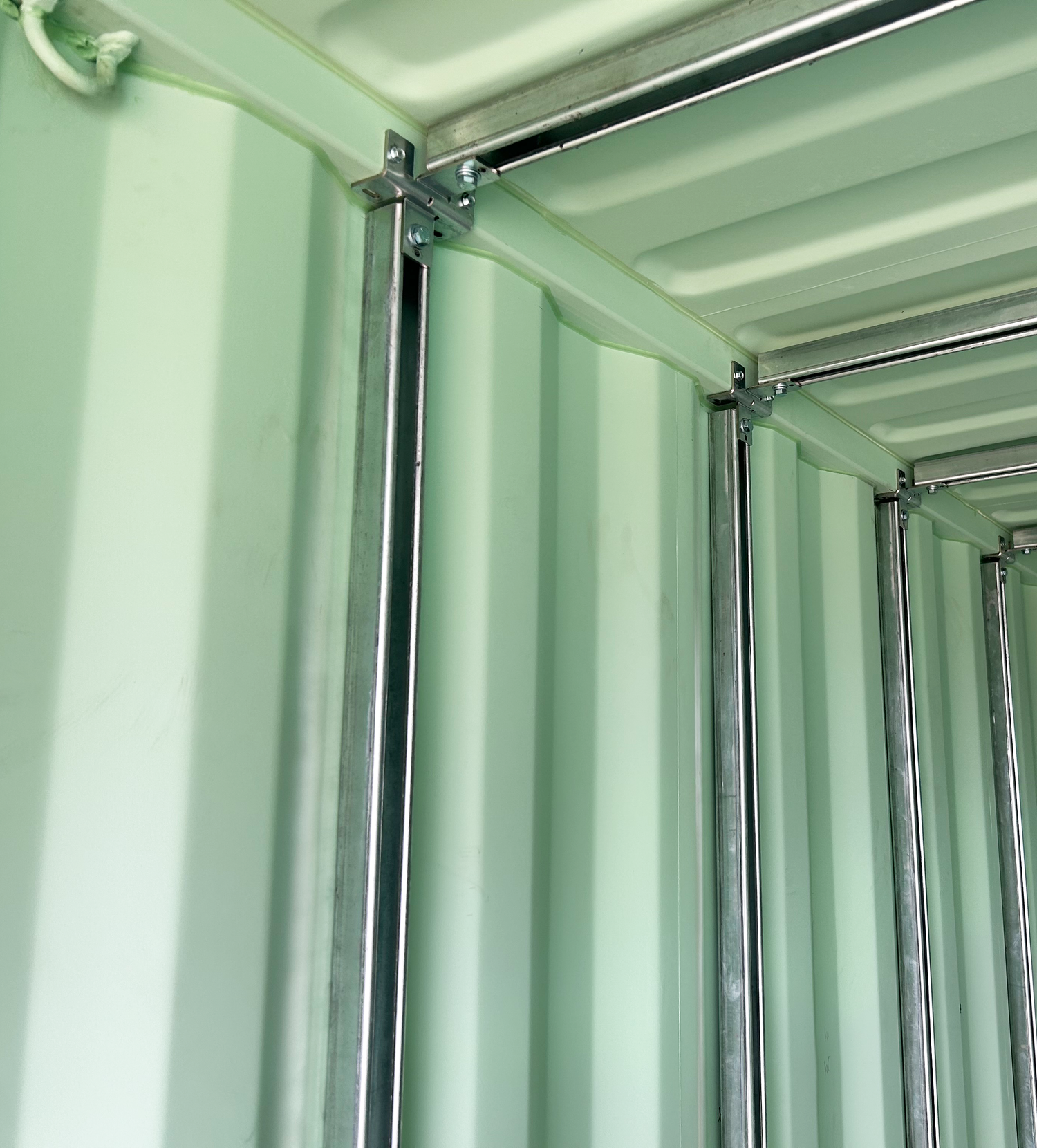 Interior of a shipping container showing galvanized strut channels mounted vertically and horizontally using modular container strut brackets for non-invasive installation.