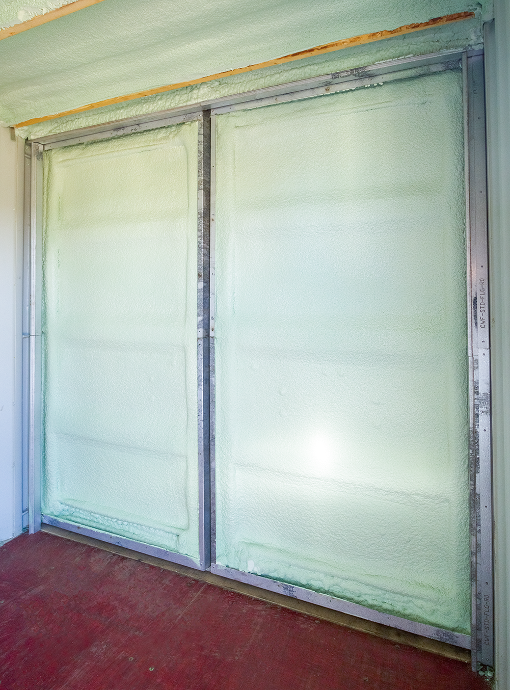 Interior container doors insulated with spray foam and framed with metal studs, showcasing a sealed and energy-efficient setup.