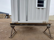 Installed fork pocket covers on the underside of a shipping container, securely blocking forklift holes to contain spray foam insulation