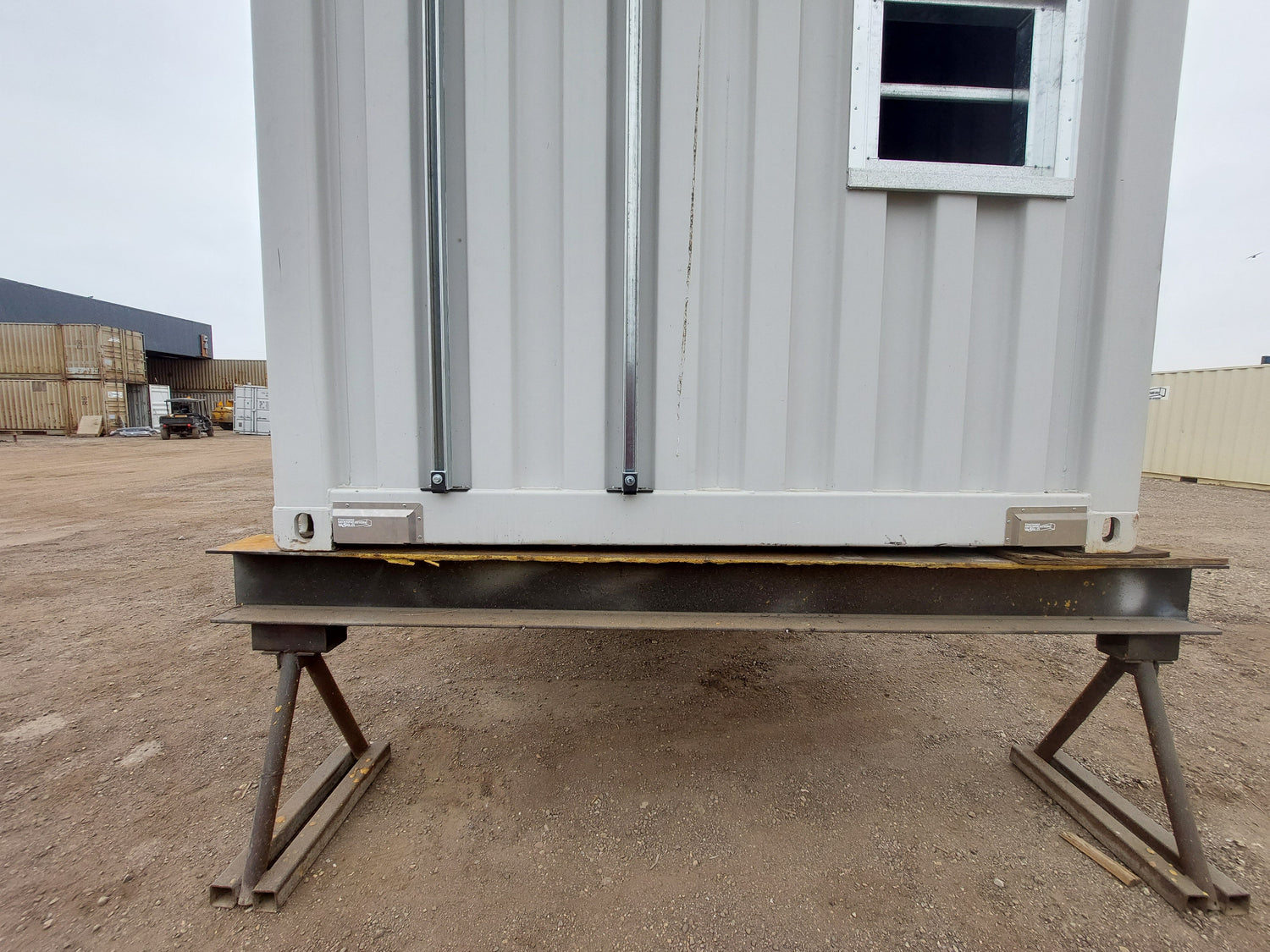 Installed fork pocket covers on the underside of a shipping container, securely blocking forklift holes to contain spray foam insulation